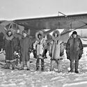 Star Air Services airmen posing in front of an airplane wearing warm clothes.