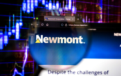 A smartphone displays a Newmont webpage before an up-trending stock chart.