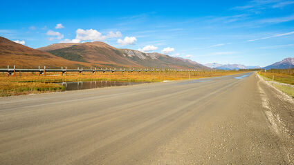 Dirt highway and oil pipeline from Alaska's North Slope.