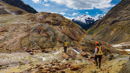 Workers hiking up an outlying rock formation at Seabridge Gold's KSM property.