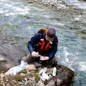 Technician collects water samples from a stream in British Columbia.