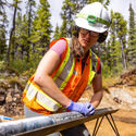 Erica lines up drill core at a battery metals mine project in Northern BC.