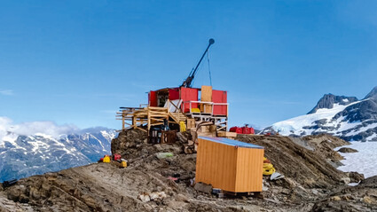 A drill rig sits atop a rocky ridge in the mountains of BC’s Golden Triangle.