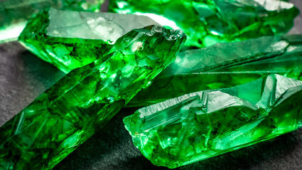 Closeup of several green rough uncut emerald crystals.