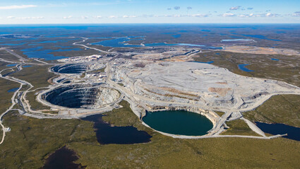 Several mine pits on a flat and barren arctic landscape with many lakes.