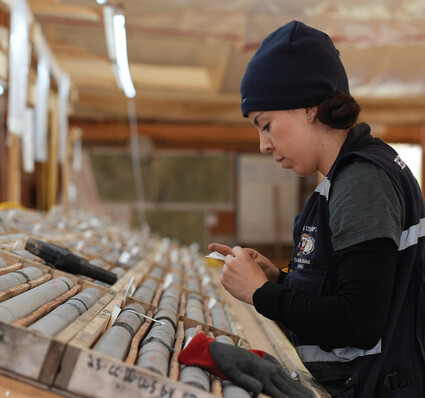 A female geotechnician tags a box of drill core at the Ranch project.