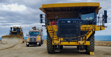 A large Cat mine truck, water truck, and dozer at the Manh Choh gold mine.