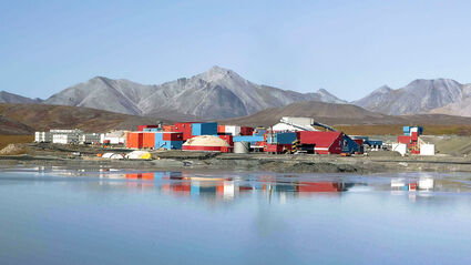 The iconic red and blue buildings at Red Dog reflect off pond at the zinc mine.