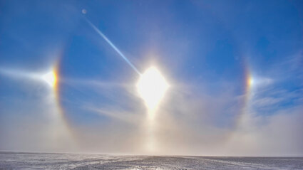 A colorful sundog encircles the sun over a frozen plain in Canada’s North.