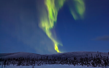 A streak of bright green northern lights over a Yukon gold exploration project.