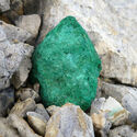 A green chunk of oxidized copper among white rocks at the Storm project in Nunavut.