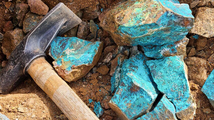 Hammer placed beside highly copper mineralized rock samples.