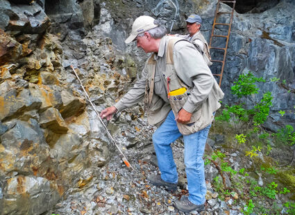 Webb and Malahoff sample a vertical rock face at the Mon gold mine project.