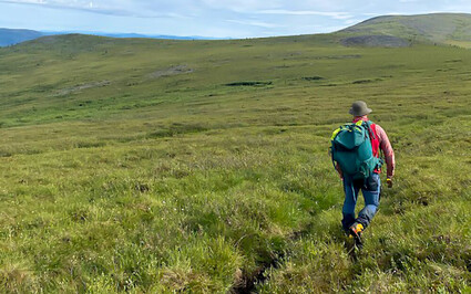 Geologist hiking through the Yukon plains in Summer.