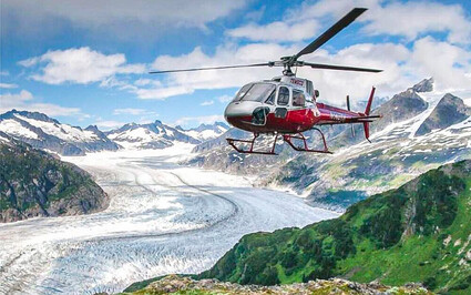 Helicopter flying over a glacial valley in Alaska.