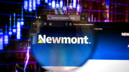 Newmont webpage in front of digital stock chart representing increased value.