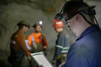 Supervisor checks his digital device in an underground silver mine.