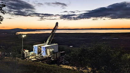 A colorful dusk horizon backdrops a drill testing the Graphite Creek deposit.