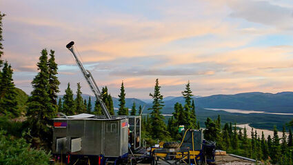 A drill tests for copper on the side of a forested hill in southwest Yukon.