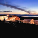 Colorful sunset behind commercial Quonset tents at a graphite project in Alaska.